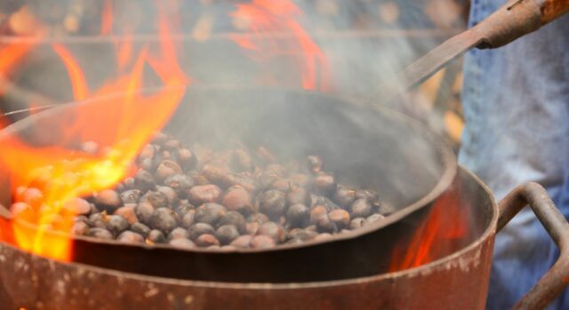 fire and the iron pan with roasted chestnuts while cooking the autumn fruits outdoors