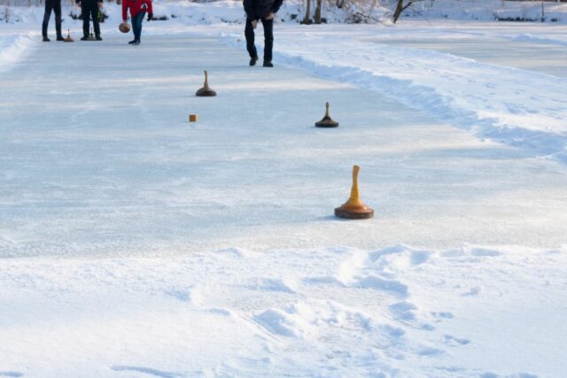 People playing curling on a frozen lake, Austria, Europe